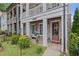 Inviting brick home with a charming porch, colorful flowers, and a 'Hello' doormat at 214 Bluestone Dr, Woodstock, GA 30188