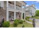 Charming brick home featuring a covered porch, well-maintained lawn, and beautifully landscaped front yard at 214 Bluestone Dr, Woodstock, GA 30188