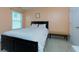 Cozy bedroom with a dark wood-framed bed and natural light from the window at 3984 Potomac Walk Ct, Loganville, GA 30052