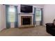 Bright living room with a stone fireplace and large windows with sheer curtains at 3984 Potomac Walk Ct, Loganville, GA 30052