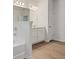 Clean bathroom with bright lighting, bath tub, vanity with drawers, wood-look flooring, and toilet at 728 Hedwig Dr, Mcdonough, GA 30252