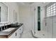Modern bathroom featuring a glass shower, double sink vanity with subway tile walls and a unique glass block window at 799 Monroe Ne Dr, Atlanta, GA 30308