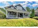 Charming two-story home with a covered front porch and manicured landscaping under a beautiful blue sky at 799 Monroe Ne Dr, Atlanta, GA 30308