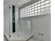 Shower featuring a glass enclosure, glass block window, and stylish green tiling at 799 Monroe Ne Dr, Atlanta, GA 30308