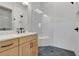 Modern bathroom features a vanity, glass shower and dark fixtures; with white tile at 150 Rolison Way, Fayetteville, GA 30214