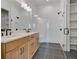 Modern bathroom features a double vanity, glass shower and dark fixtures; ample shelving for storage at 150 Rolison Way, Fayetteville, GA 30214
