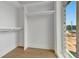 Bright walk-in closet features custom shelving, hanging rods and natural light from a nearby window at 150 Rolison Way, Fayetteville, GA 30214