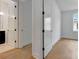 Bright hallway featuring wood floors, white walls, doors, and trim leading to the bathroom and bedroom at 150 Rolison Way, Fayetteville, GA 30214