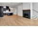 Open-concept living room and kitchen with light hardwood floors and a fireplace at 150 Rolison Way, Fayetteville, GA 30214