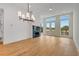 Open-concept living room with modern light fixture and a fireplace, providing abundant natural light at 150 Rolison Way, Fayetteville, GA 30214