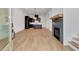 Open-concept living room and kitchen with light hardwood floors and a fireplace at 150 Rolison Way, Fayetteville, GA 30214