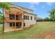 Backyard view of a two-story home with a brick exterior, a covered patio, and a spacious lawn at 1525 Tapestry Rdg, Lawrenceville, GA 30045