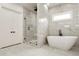 Luxurious bathroom with freestanding tub and marble-style tile at 1525 Tapestry Rdg, Lawrenceville, GA 30045