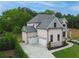 Aerial view of a brick home with an attached garage, landscaped yard and a concrete driveway at 1525 Tapestry Rdg, Lawrenceville, GA 30045