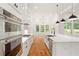 Kitchen features stainless appliances, marble countertops, and an island overlooking the backyard at 1525 Tapestry Rdg, Lawrenceville, GA 30045