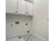 A white laundry room with marble tile floors, white cabinets and stainless steel appliances at 1525 Tapestry Rdg, Lawrenceville, GA 30045