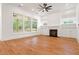 Living room with hardwood floors, a fireplace, built-in shelving, and backyard views at 1525 Tapestry Rdg, Lawrenceville, GA 30045