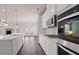 Modern white kitchen with stainless steel appliances and island at 1798 Lacebark Elm Way, Lawrenceville, GA 30045