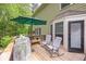Cozy back deck with rocking chairs and umbrella with peaceful views of wooded backyard at 10540 Waters Ridge Dr, Alpharetta, GA 30022