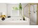 Bathroom featuring garden tub, separate shower, and large window letting in natural light at 10540 Waters Ridge Dr, Alpharetta, GA 30022