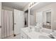 Bright bathroom with double sinks, modern fixtures, a shower with a curtain, and white cabinets at 10540 Waters Ridge Dr, Alpharetta, GA 30022