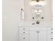 Bright, all-white bathroom features modern vanity with ample storage and a gold-framed mirror at 10540 Waters Ridge Dr, Alpharetta, GA 30022