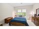 Cozy bedroom featuring a comfortable bed, wood accents, and natural light from a window at 10540 Waters Ridge Dr, Alpharetta, GA 30022