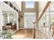 Bright foyer with hardwood floors, a wooden staircase, and a view into other rooms through large open archways at 10540 Waters Ridge Dr, Alpharetta, GA 30022