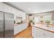 Bright kitchen with stainless steel appliances, white cabinets, and hardwood floors adds a touch of timeless elegance at 10540 Waters Ridge Dr, Alpharetta, GA 30022