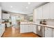 Bright kitchen with white cabinets, stainless steel appliances, hardwood floors, and a view to an eat-in dining area at 10540 Waters Ridge Dr, Alpharetta, GA 30022