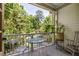 Relaxing back porch with a glass table, chairs, lush greenery and natural light at 164 Ridley Cir, Decatur, GA 30030