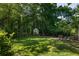 Tranquil backyard with a lush green lawn and a charming chicken coop surrounded by mature trees at 164 Ridley Cir, Decatur, GA 30030