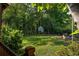 Expansive backyard with lush green lawn and a charming chicken coop nestled among mature trees at 164 Ridley Cir, Decatur, GA 30030