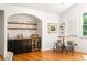 Charming bar area features custom shelving, a wine fridge, and seating for entertaining with beautiful hardwood floors at 164 Ridley Cir, Decatur, GA 30030