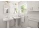 Well-lit bathroom with double sinks, white tiling, and modern fixtures at 164 Ridley Cir, Decatur, GA 30030