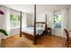 Sun-filled bedroom with hardwood floors, a canopy bed and large windows with white curtains at 164 Ridley Cir, Decatur, GA 30030