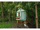 Backyard chicken coop amongst mature trees, providing a charming and functional addition to the property at 164 Ridley Cir, Decatur, GA 30030