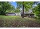 Overgrown backyard with mature trees and detached storage shed at this gray siding home at 2607 Jefferson Ter, Atlanta, GA 30344