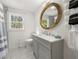 Bathroom featuring a gray vanity, a decorative mirror, and a shower with gray and white tiling at 2710 Hedgewood Nw Dr, Atlanta, GA 30311