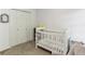 Neutral toned Bedroom featuring a white crib, closet, and plush carpet at 3322 Woodsfield Ne Dr, Marietta, GA 30062