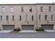 Rear exterior view showcasing a row of townhomes with attached garages and well-maintained grounds at 3433 Landen Pine Ne Ct, Atlanta, GA 30305
