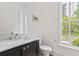 Bright powder room featuring a modern vanity with a marble countertop and a window view at 3433 Landen Pine Ne Ct, Atlanta, GA 30305