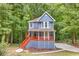 Charming blue two-story home with a cozy front porch and staircase surrounded by lush greenery at 1310 Ridgeview Rd, Auburn, GA 30011