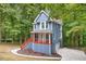 Charming two-story home features a covered porch, upper deck, and is surrounded by a lush, wooded landscape at 1310 Ridgeview Rd, Auburn, GA 30011