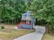Charming blue two-story home nestled in a serene wooded setting with inviting front porch and long driveway at 1310 Ridgeview Rd, Auburn, GA 30011