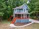 Two-story blue home with a charming porch, freshly landscaped yard, and private driveway in a wooded setting at 1310 Ridgeview Rd, Auburn, GA 30011