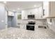 Updated kitchen featuring granite countertops, white cabinets, stainless appliances, and modern lighting at 1310 Ridgeview Rd, Auburn, GA 30011