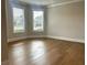 Bright, empty room with gleaming hardwood floors, large windows, and refined crown molding, ready to personalize at 4050 Sierra Vista Cirs, Cumming, GA 30040