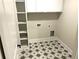 Well-organized laundry room with modern appliances, shelving, and patterned tile flooring at 4050 Sierra Vista Cirs, Cumming, GA 30040