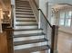 Elegant staircase featuring wood steps, iron spindles, and a decorative chandelier, adds architectural interest at 4050 Sierra Vista Cirs, Cumming, GA 30040